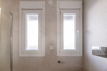 White aluminum double windows in a bathroom