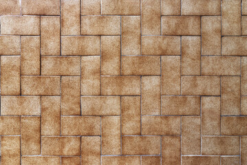 A wall covered in small rectangular brown tiles - Powered by Adobe