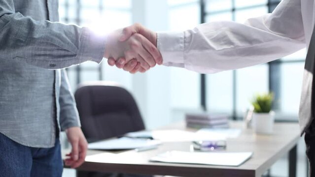 Office workers shake hands in the office