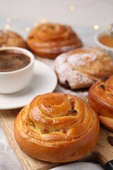 Delicious rolls with raisins on table, closeup. Sweet buns