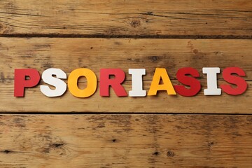 Word Psoriasis made of paper letters on wooden table, top view