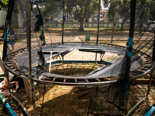 a black trampoline that was damaged, broken in the middle