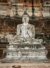 Seated bronze stone worship Buddha statue and red brick Thai temples at the Wat Yai Chai Mongkhon in Ayutthaya Thailand