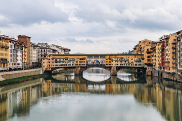 View of the Arno River in Florence and the famous Ponte Vecchio (Old Bridge). - obrazy, fototapety, plakaty