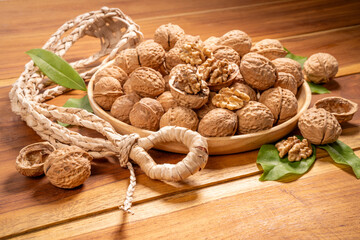 Walnuts in wooden bowl on wooden background, Walnuts kernels in wooden basket on wooden table.
