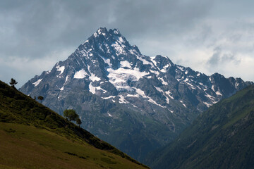 View of the peak of Mount Pshish - the highest peak near the village of Arkhyz on a sunny summer day, North Caucasus, Karachay-Cherkessia, Russia
