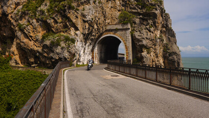Person driving bike through highway tunnel, Amalfi Coast, Italy