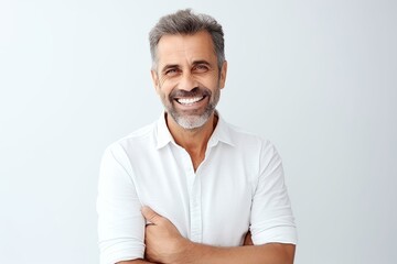 Handsome mature man smiling and looking at camera while standing against grey background