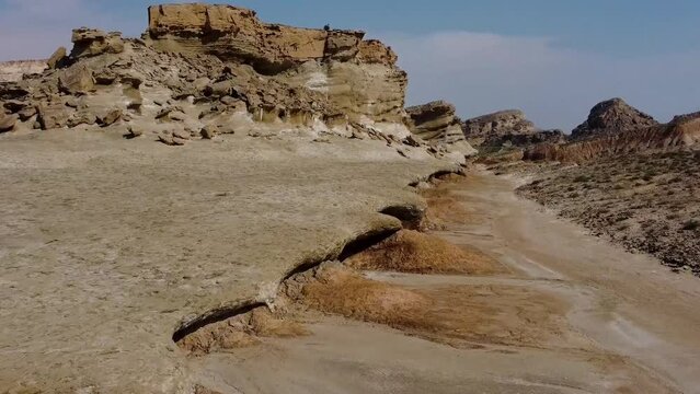 Yardang landform in coastal beach dry mud rocky mountain erosion abrasion cloudy blue sky in background wonderful landscape of attraction adventure hiking in iran Qatar border harbor unique culture