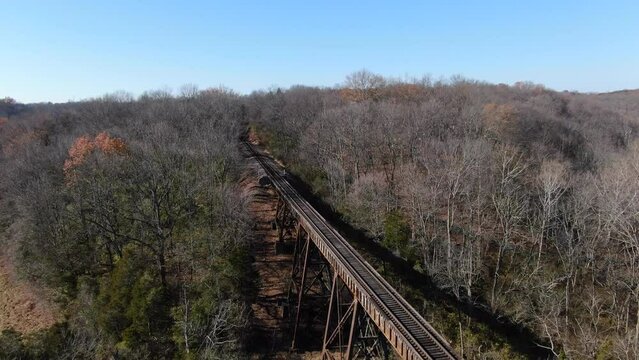 Aerial Shot Pulling Away From the End of the Pope Lick Railroad Trestle Where the Tracks Curve into the Forest in Louisville Kentucky.