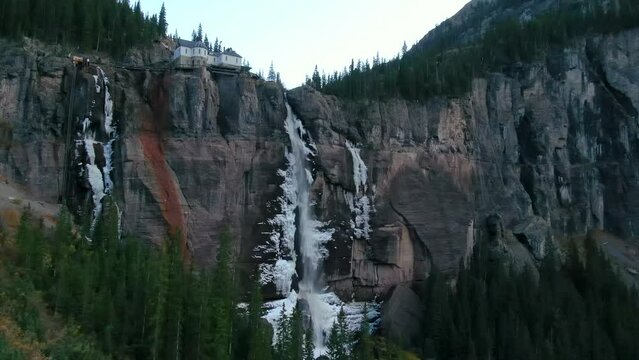 Bridal Veil Falls Telluride Colorado aerial drone frozen ice waterfall autumn sunset cool shaded Rocky Mountains Silverton Ouray Millon Dollar Highway historic town landscape slow downward motion