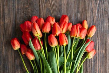 Fresh orange tulips on a wooden background. Springtime. Greeting card with copy space for Valentine's Day, Woman's Day and Mother's Day.