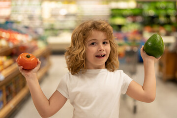 Fototapeta premium Child in food shop in food market store. Kids shopping in food shop supermarket. Sales, shop and shopping. Kid in shop. Shopping market. Shopping center. Child buy food in supermarket.