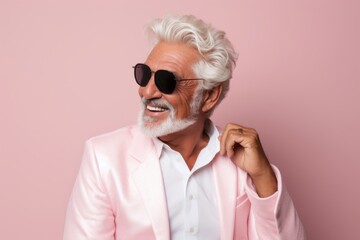 Portrait of cheerful senior man in sunglasses. Isolated on pink background.