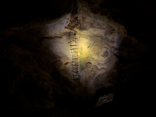 A ladder illuminated in the dark for a creepy cave image in Carlsbad Caverns National Park. Old...