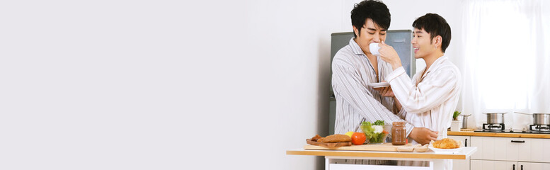 Banner Happy gay couple enjoy breakfast in kitchen drinking coffee. Panorama Two best friends LGBTQ relation partner home cooking. Wide Happiness romance homosexual marriage lifestyle with copy space