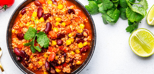 Chili con carne, mexican dish with minced beef, red beans, paprika, corn and hot peppers in spicy tomato sauce, tex-mex cuisine, white background, top view