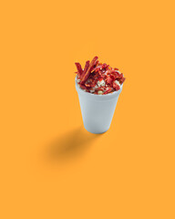 Corn Preparation in a Cup, Esquite, Mexican Snack, Street Food, Spicy, Chamoy, Chili Powder, trolelote, Minimalist orange Background