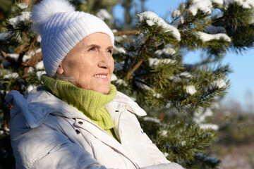 Happy old woman in a fur coat in the winter. 