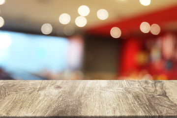 Empty dark wooden table in front of abstract blurred boken bankground of restaurant. Can used for...