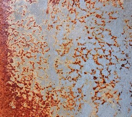 A silver metal plate covered with orange rust marks. texture background of weathered and rusted metal, 