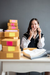 Vertical image of an Asian online business owner taking orders for customers using a smartphone. On...