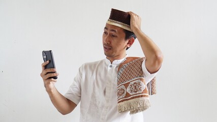 Asian Moslem man excited happy when in video call using mobile phone