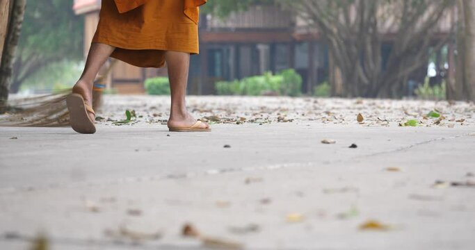 Monks are cleaning the temple area. Monks are sweeping the floor.