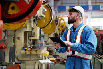 worker or engineer working on tablet and checking machine in the factory