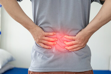 Office Syndrome: Man touching lower back at pain point with red notes, back and waist pain. Asian...