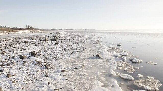 Aerial Drone Shot of Frozen Lakeshore and Laguna At Daytime