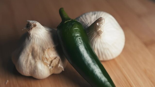 Green chili pepper and garlic on bamboo cutting board 
