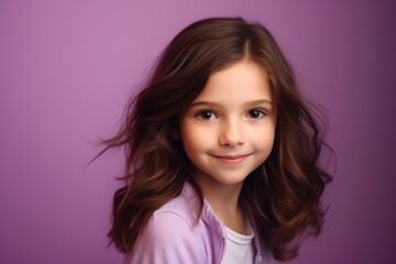 Portrait of a beautiful little girl with long hair on a purple background.