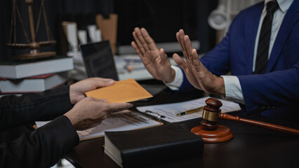 Lawyers refuse to accept bribes from businessmen in awarding contracts. Concept of corruption and anti-bribery and corruption. Hammer. Judge. Brass scale. close-up law office