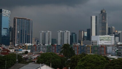 Fototapeta premium Image of tall buildings in a cloudy sky and trees
