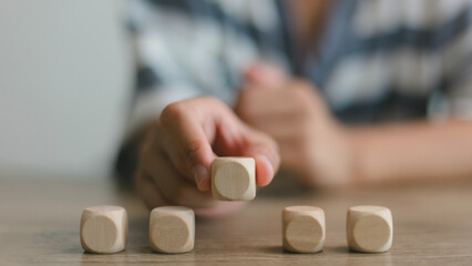 Businesswomen stack blank wooden cubes on the table with copy space, empty wooden cubes for input...