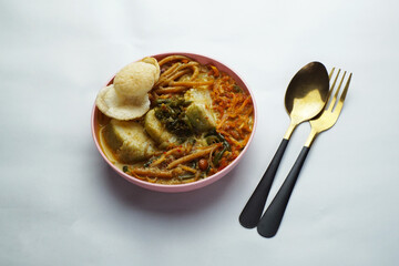 Lontong with curry soup accompanied by fried sweet potatoes chili sauce and noodles