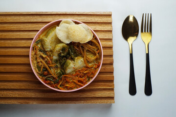 Lontong with curry soup accompanied by fried sweet potatoes chili sauce and noodles