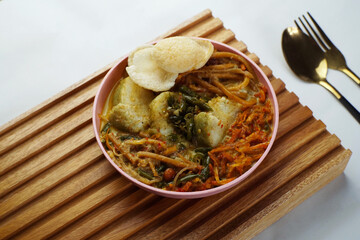 Lontong with curry soup accompanied by fried sweet potatoes chili sauce and noodles