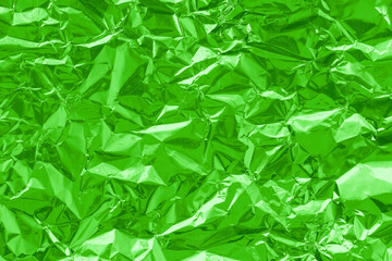 Shiny green lime foil texture background, pattern of wrapping paper with crumpled and wavy.
