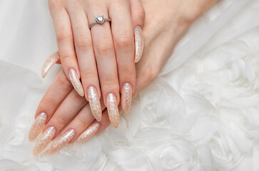 Hand of a young woman with white pearl  manicure