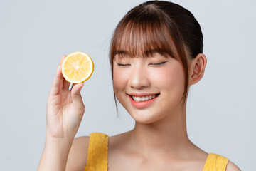 Portrait of adorable smiling girl with lemon, over white