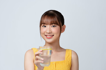 Vitamin Shot. Attractive asian woman drinking mineral water with lemon from glass