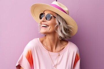 Portrait of a happy mature woman in summer hat and sunglasses.