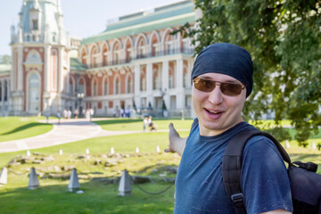 A guy in a black bandana and sunglasses says welcome, inviting you to visit historical palace