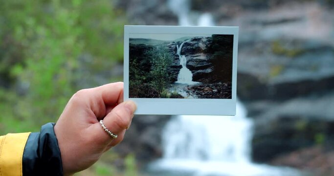 Hand, picture and photography of waterfall, nature and outdoor adventure for memory and polaroid. Woman, nostalgia and photo of rainforest, water and tourism trip for scrapbooking and scenery