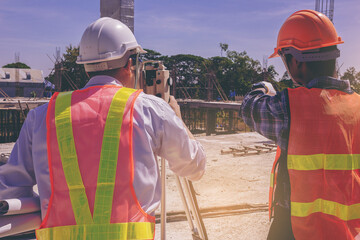 Engineer or surveyor worker working with theodolite transit equipment at outdoors construction...