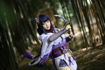 Portrait of a beautiful young woman game cosplay with samurai dress costume on Japanese garden