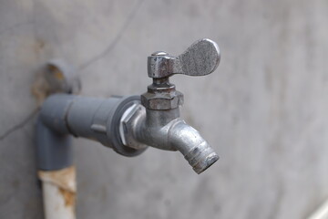 a water faucet and pipe attached to the wall