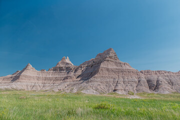Multi-colored rock formations and mountains rising over the plains of Badlands National Park